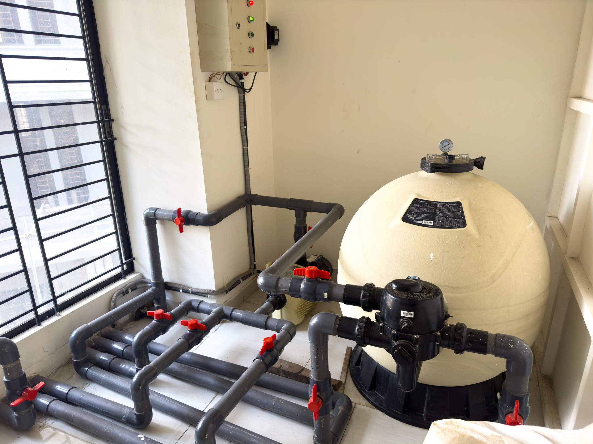 Modern Water Filtration System with PVC Piping and Pressure Gauge in Indoor Utility Room. Water Filtration System